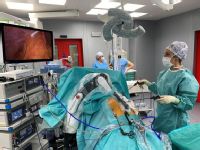 Chirurgové při laparoskopické operaci za pomoci robotického ramene